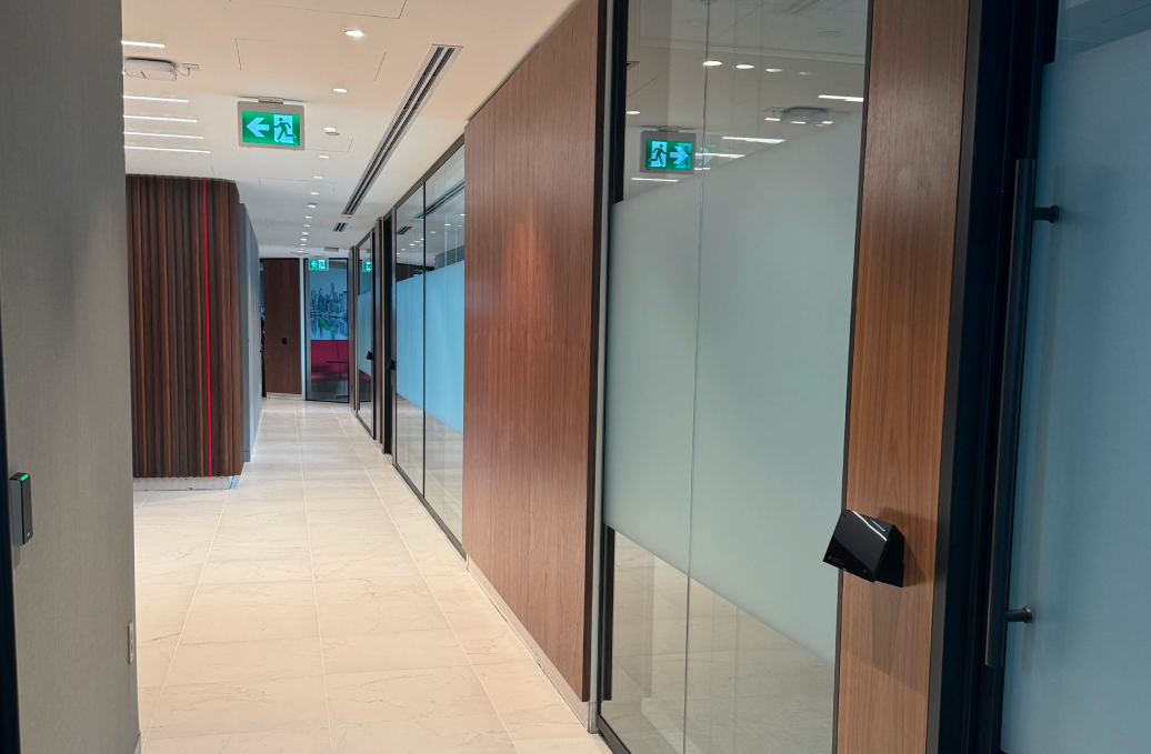 alt="Movable glass walls installed by Systemax in modern office space."