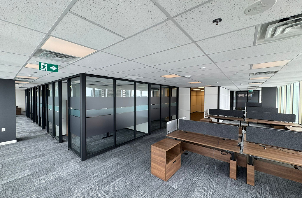 alt="Movable glass walls installed by Systemax in modern office space."