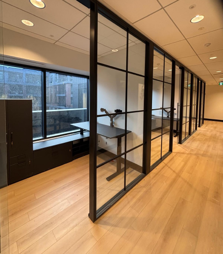 alt="Movable glass walls installed by Systemax in modern office space."