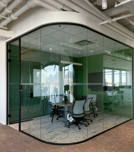 alt="Movable curved glass walls installed by Systemax in modern office space."
